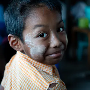 Boy with Thanaka on his face looking back