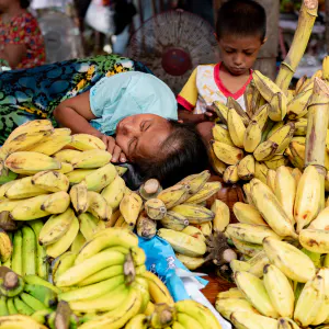 Mother sleeping on the other side of the pile of bananas