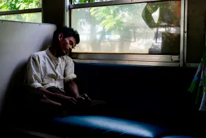 列車の車内で熟睡する男