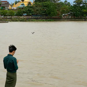 Man throwing offerings into river