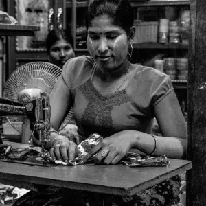 Woman sewing in dim shop
