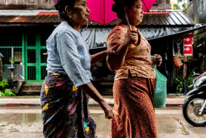Two women walking together in drizzle