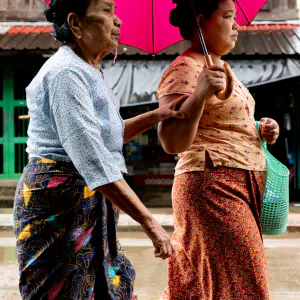 Two women walking together in drizzle