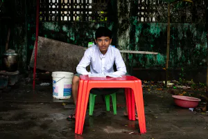 Schoolboy studying at the red table