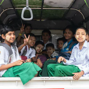 Students sitting on luggage carrier