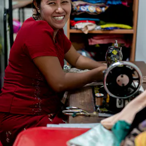 Woman smiled beside sewing machine