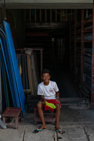 Boy sitting in storefront with a smile