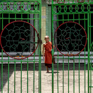 Little Buddhist monk on the other side of the gate