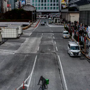 Bicyce running wide street in front of Shinjuku Station