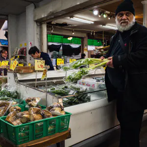 スーパーマーケットの野菜売り場に立つ男