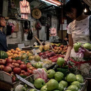 Woman browsing guavas in fruit shop