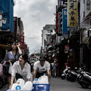 Woman and man walking while pushing box
