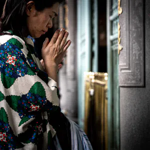 Woman praying seriously in Lungshan Temple