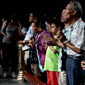 Young and old people praying in Lungshan Temple