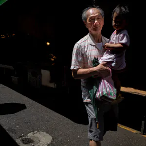 Little kid held by grandfather in Bailan Market