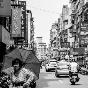 Older woman walking with umbrella near Bailan Market