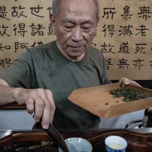 Man setting tea leaves in cup