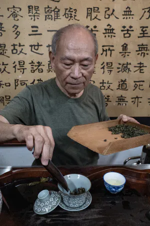 Man setting tea leaves in cup