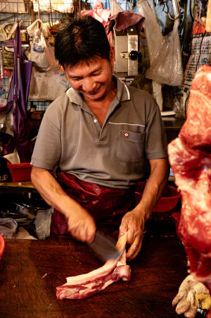 Butcher cutting happily