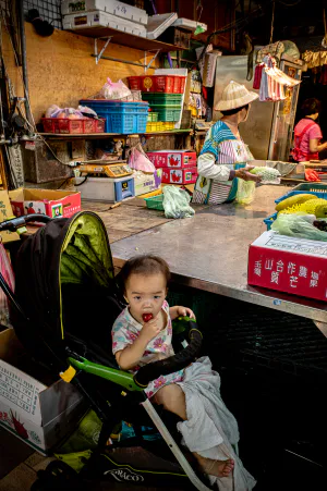Baby on baby buggy in Chenggong Market