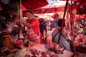 Woman cutting pork in Khlong Toei Market