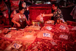 Two women working together in a butcher in Khlong Toei Market