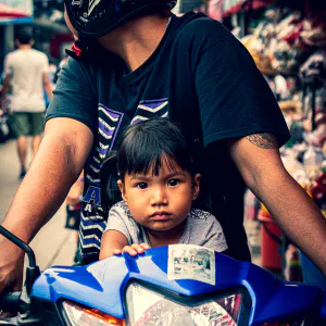 Little girl riding a motorbike with her father