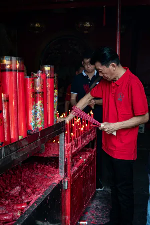 金徳院で燭台を片付ける赤いポロシャツの男