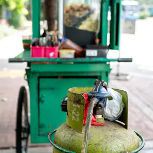 Green gas cylinder next to a food stall