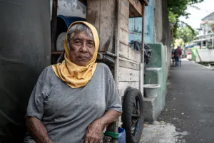 Older woman relaxing by the wayside in Jakarta