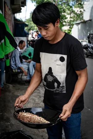 Young man shaking a wok