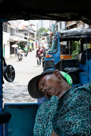 Bajaj driver sleeping on his vehicle