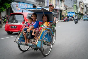 Becak running with parents and children