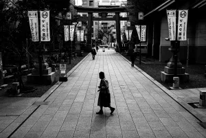 Old woman crossing the approach to Tomioka Hachimangu Shrine