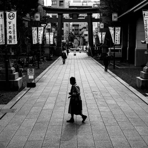Old woman crossing the approach to Tomioka Hachimangu Shrine