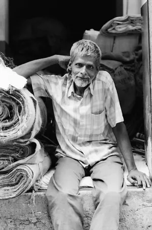 Man beside rolled textiles