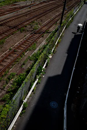 White umbrella walking by the railroad tracks