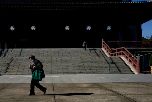Woman walking in front of the main hall of Zojo-ji Temple