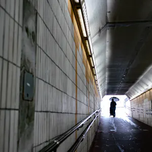 Man pushing strollers through a tunnel