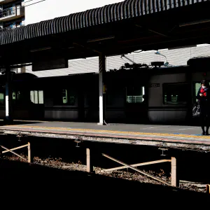 High school girl waiting for a train on the platform of Keisei Sakura Station