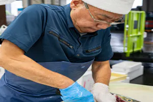 Man cutting fish at the Adachi market