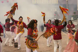 Women dancing in the smoke with flagged sticks in their hands