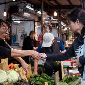 八百屋でお釣りを受け取る女性