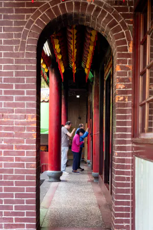 Family paying homage to the god enshrined in the back of the Dadaocheng Cisheng Temple