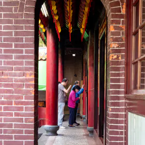 Family paying homage to the god enshrined in the back of the Dadaocheng Cisheng Temple