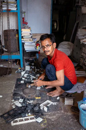 Man dismantling parts with a hammer