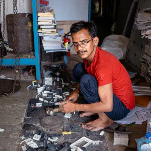 Man dismantling parts with a hammer