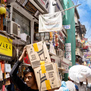 Young man carrying big boxes on his shoulder