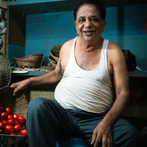 Man selling tomatoes and green peppers