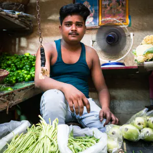 緑色の野菜を売る男